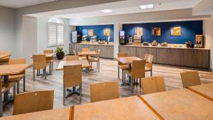 a dining room with tables and chairs and a counter at Best Western Tampa in Tampa