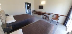 a hotel room with two beds and a desk at The Furlong in Hawera