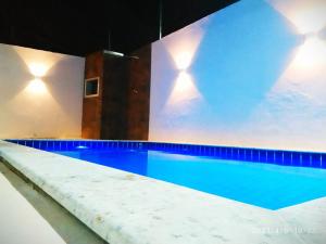 ポルト・セグロにあるDúplex em Porto Seguro com piscina a 8 minutos das praiasの建物内の青い水のスイミングプール