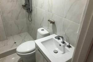 a white bathroom with a toilet and a sink at (5)Modern Miraflores tourist area apartment in Lima