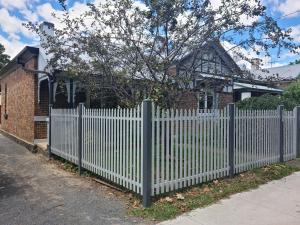 une clôture blanche devant une maison dans l'établissement Arden on McLachlan, à Orange