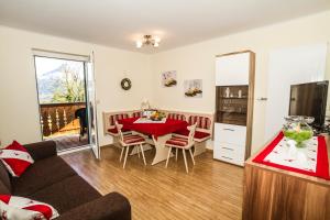 a living room with a couch and a table and a kitchen at Haus Bergland in St. Wolfgang