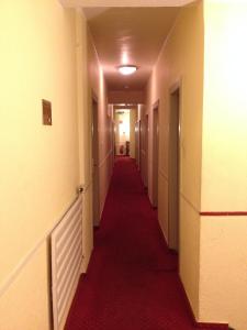 a long hallway with a red carpet in a building at Domo Hotel Mondial in Düsseldorf +28 photos