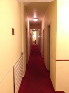 a long hallway with a red carpet in a building at Domo Hotel Mondial in Düsseldorf