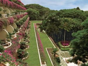 a garden with pink flowers on the side of a building at The Oberoi Bengaluru in Bengaluru