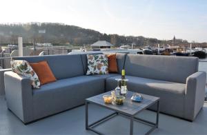 a blue couch and a table with a bottle of wine at Floating vacationhome Tenerife in Maastricht