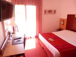 a hotel room with a bed and a large window at Logis De La Loire in Ancenis