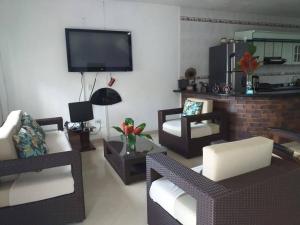 uma sala de estar com duas cadeiras e uma televisão em Casa de Huespedes Villa Hermosa em La Vega