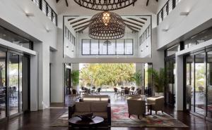 a lobby with a chandelier and tables and chairs at RACV Noosa Resort in Noosa Heads