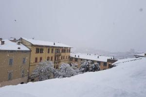 een met sneeuw bedekte stad met gebouwen op de achtergrond bij LA GHIBELLINA. confortevole,posizione privilegiata in Siena