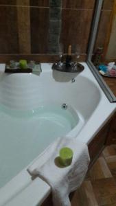 a white bath tub with a green bowl in it at Cabaña Exclusiva in Bahía Blanca