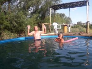 two people are in a swimming pool at Cabaña Exclusiva in Bahía Blanca