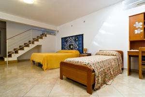 une chambre d'hôtel avec 2 lits et un escalier dans l'établissement Open Space San Cusumano, à Erice