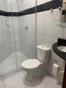 a bathroom with a toilet and a shower and a sink at Pousada Villa Galinhos in Galinhos