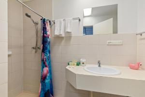 a bathroom with a sink and a shower with a mirror at Cosmo on Bank in Adelaide