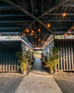 une passerelle couverte avec des plantes en pot dans un bâtiment dans l'établissement Wao Jungle Venao, à Playa Venao