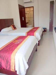 two beds in a hotel room next to each other at Victoria Phu Quoc hotel Beachfront Night market in Phu Quoc