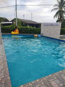 a person in a raft in a swimming pool at Noppakhun Resort in Ban Mai