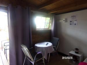 a small table and chairs in a room with a window at Les Aubepines in La Plaine des Palmistes