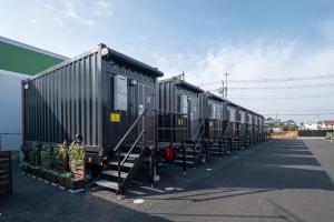 una fila de vagones estacionados en un estacionamiento en HOTEL R9 The Yard Noda, en Noda