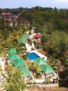 an aerial view of a resort with a pool and umbrellas at Green Kubu Asri Villa in Nusa Penida