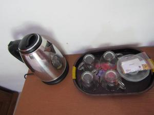 a suitcase with cups and a tea kettle on a table at Penginapan Udin Syariah Bukit Rhema in Magelang