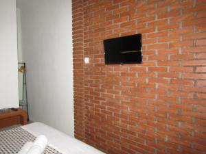 a brick wall with a tv on top of it at Penginapan Udin Syariah Bukit Rhema in Magelang