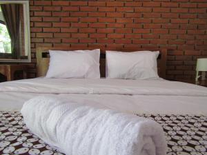 a large white bed with white sheets and pillows at Penginapan Udin Syariah Bukit Rhema in Magelang