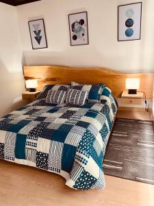 a bedroom with a bed with a blue and white comforter at Apartamento zona colonial lindísimo 101 in Zipaquirá