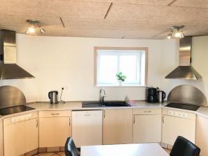 a kitchen with white cabinets and a sink and a window at Egebjerggaard Bed & Breakfast in Sig