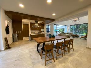 een keuken en woonkamer met een houten tafel en stoelen bij Casa Huitzil - La mejor casa de Malinalco con alberca y jacuzzi climatizados in Malinalco