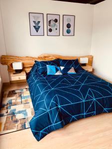 een bed met een blauw dekbed in een slaapkamer bij Apartamento zona colonial lindísimo 202 in Zipaquirá