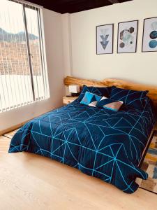 een bed met een blauw dekbed in een slaapkamer bij Apartamento zona colonial lindísimo 202 in Zipaquirá