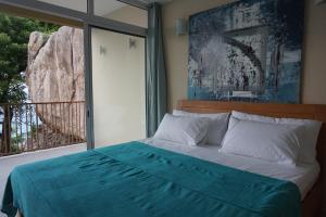 a bedroom with a bed and a large window at Maka Bay Self Catering in Victoria