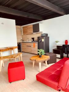 een woonkamer met een rode bank en een keuken bij Apartamento zona colonial lindísimo 202 in Zipaquirá