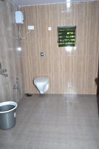 a bathroom with a toilet and a window at AARYA FARM in Bhom