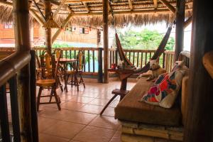 a room with a porch with hammocks and a table at La Facha Hostal Restaurant Surf in Mompiche