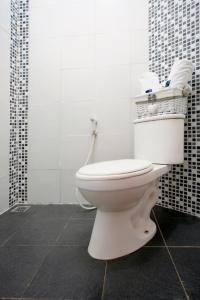 a bathroom with a white toilet in a room at D'Paragon Trikora in Palembang