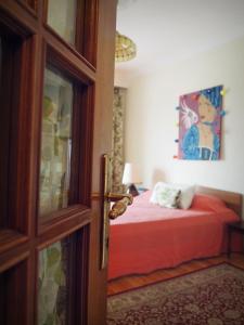 um quarto com uma cama com lençóis vermelhos e uma porta em Sunny apartment near the center em Tessalônica