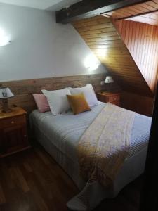 1 dormitorio con 1 cama con almohadas y 2 lámparas en Ço d´Eric, en Vielha