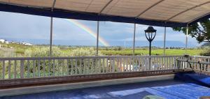 a rainbow is seen from the deck of a house at The Lake House in Migdal
