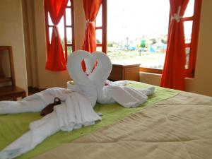 Dois cisnes de toalha estão sentados numa cama em Runa Wasi Quilotoa em Quilotoa