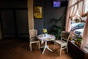 特爾古穆列什的住宿－Pensiunea Flora，一张桌子、两把椅子和一张桌子,上面有鲜花