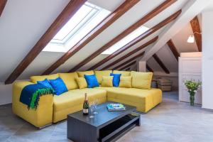 un sofá amarillo en una sala de estar con mesa en Apartments Arla Exclusive, en Dubrovnik