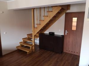 escalera de madera en una habitación con puerta de madera en Adlerek Krynica, en Krynica Morska