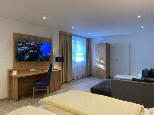 een hotelkamer met een bed, een bureau en een televisie bij Nordseehotel Apartments in Wilhelmshaven
