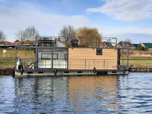 ein Hausboot liegt auf dem Wasser angedockt in der Unterkunft Hausboote Unteres Odertal Hausboot Seeadler in Schwedt