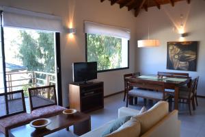 sala de estar con sofá y mesa con TV en Piedras Blancas Carilo en Cariló