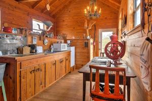a kitchen with wooden cabinets and a table in a cabin at Ark Bunkhouse Fredericksburg Hideaway with Hot Tub in Fredericksburg +18 photos