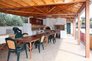 zona de comedor al aire libre con mesa de madera y sillas en Alexandros Rooms & Studios en Skopelos Town